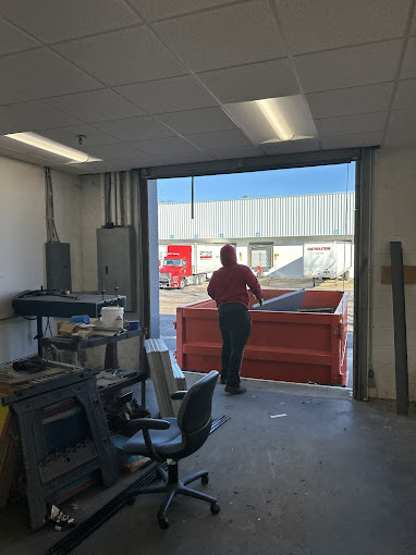 A woman in a red shirt standing in a warehouse