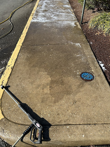 A water hose is attached to a sidewalk